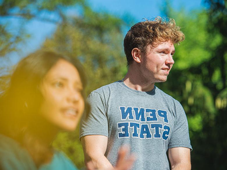 Students hang out on campus at Penn State Altoona, one wearing a Penn State shirt.